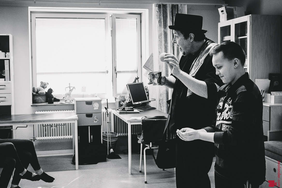 Peter performing a trick with a cup and a ball in the classroom